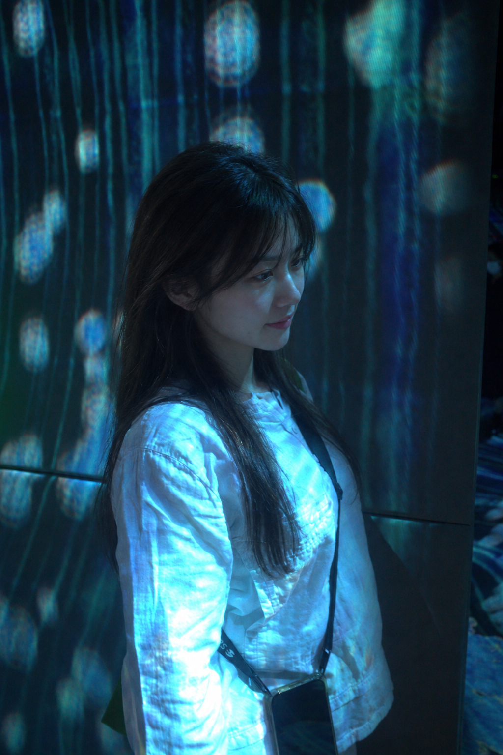 Chloe 在藍色水景投影前留影