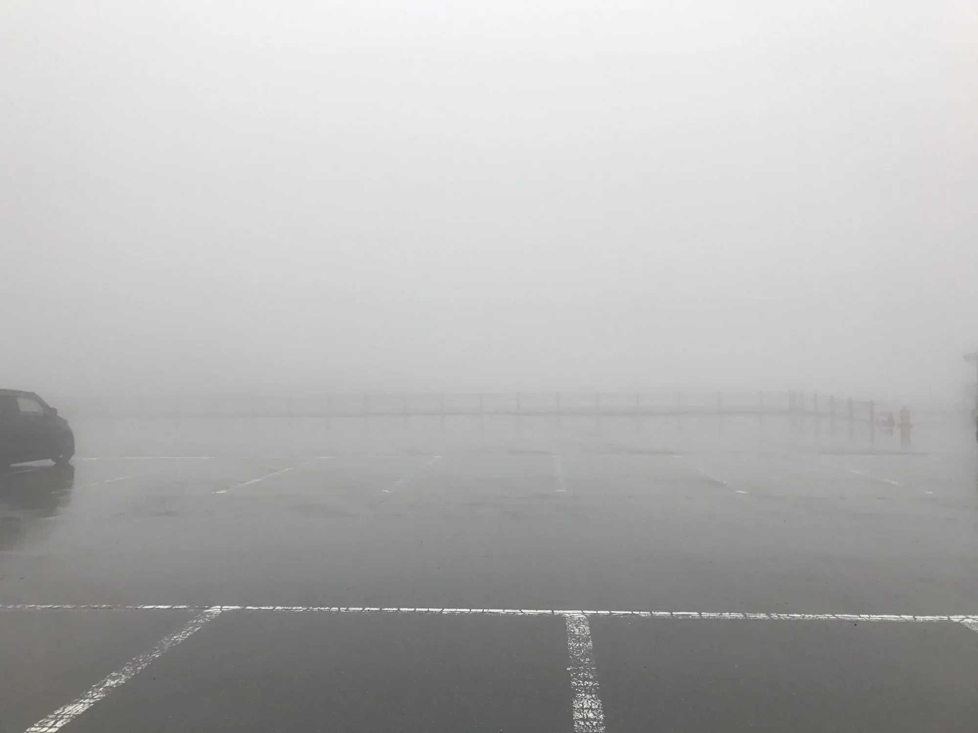 雨霧中的草千里停車場與欄杆近景
