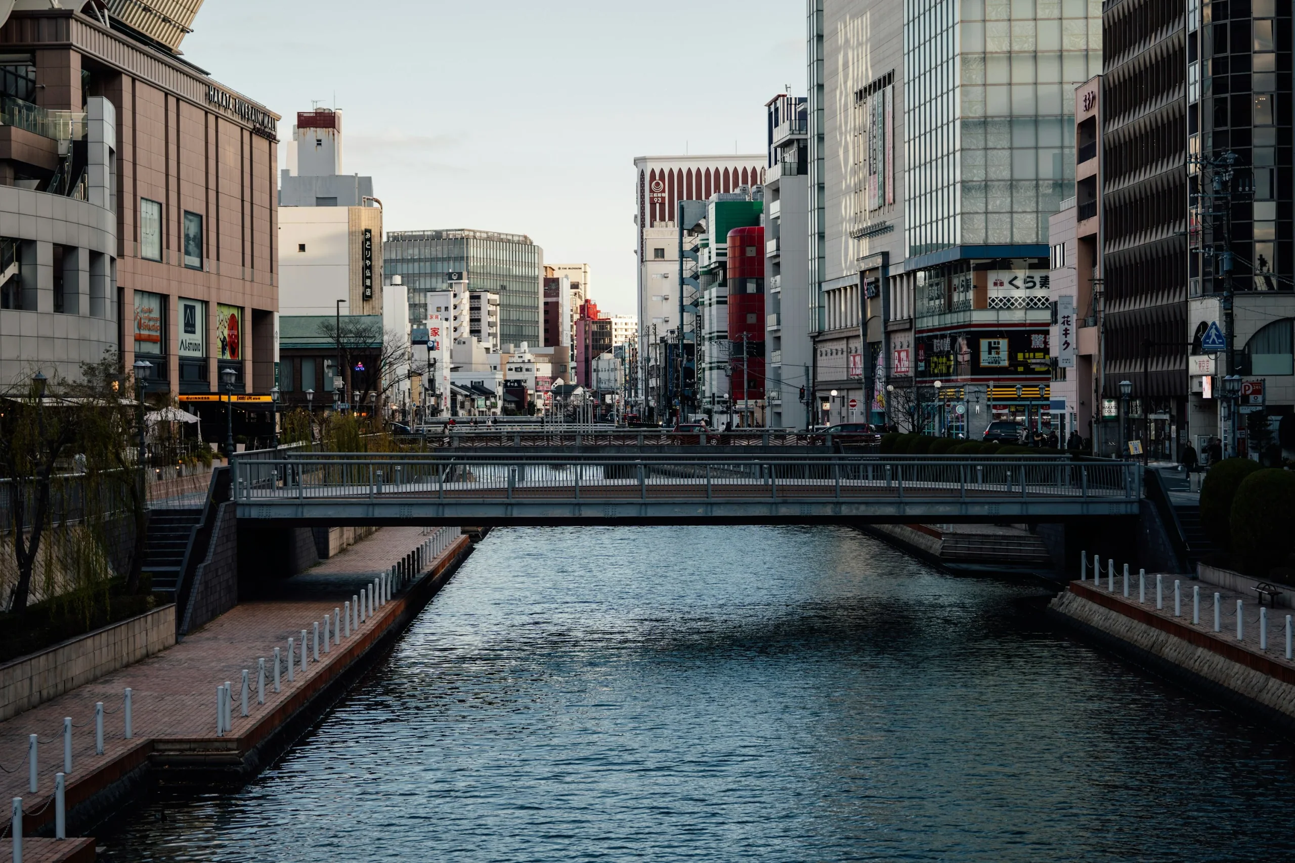 福岡市區河道沿岸建築，右岸可見 Alpen FUKUOKA 招牌