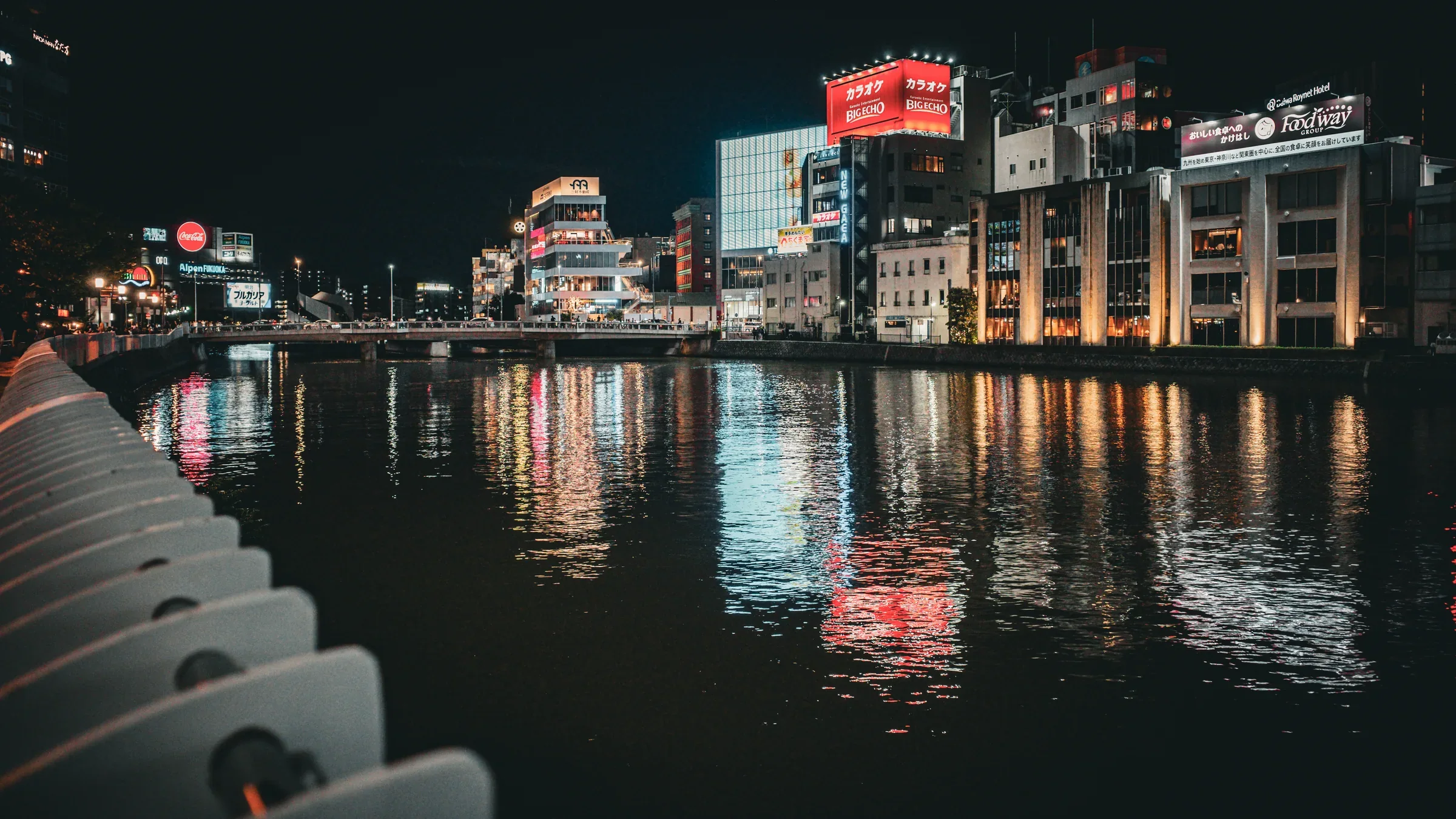 夜色中的那珂川與中洲兩岸街景，河面映出商業區燈光