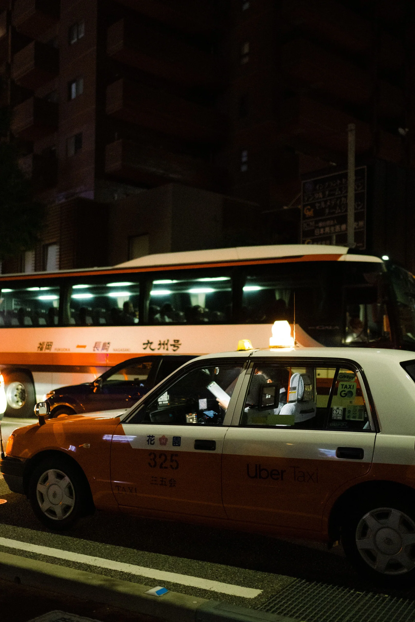 福岡市夜間街道上的計程車與巴士