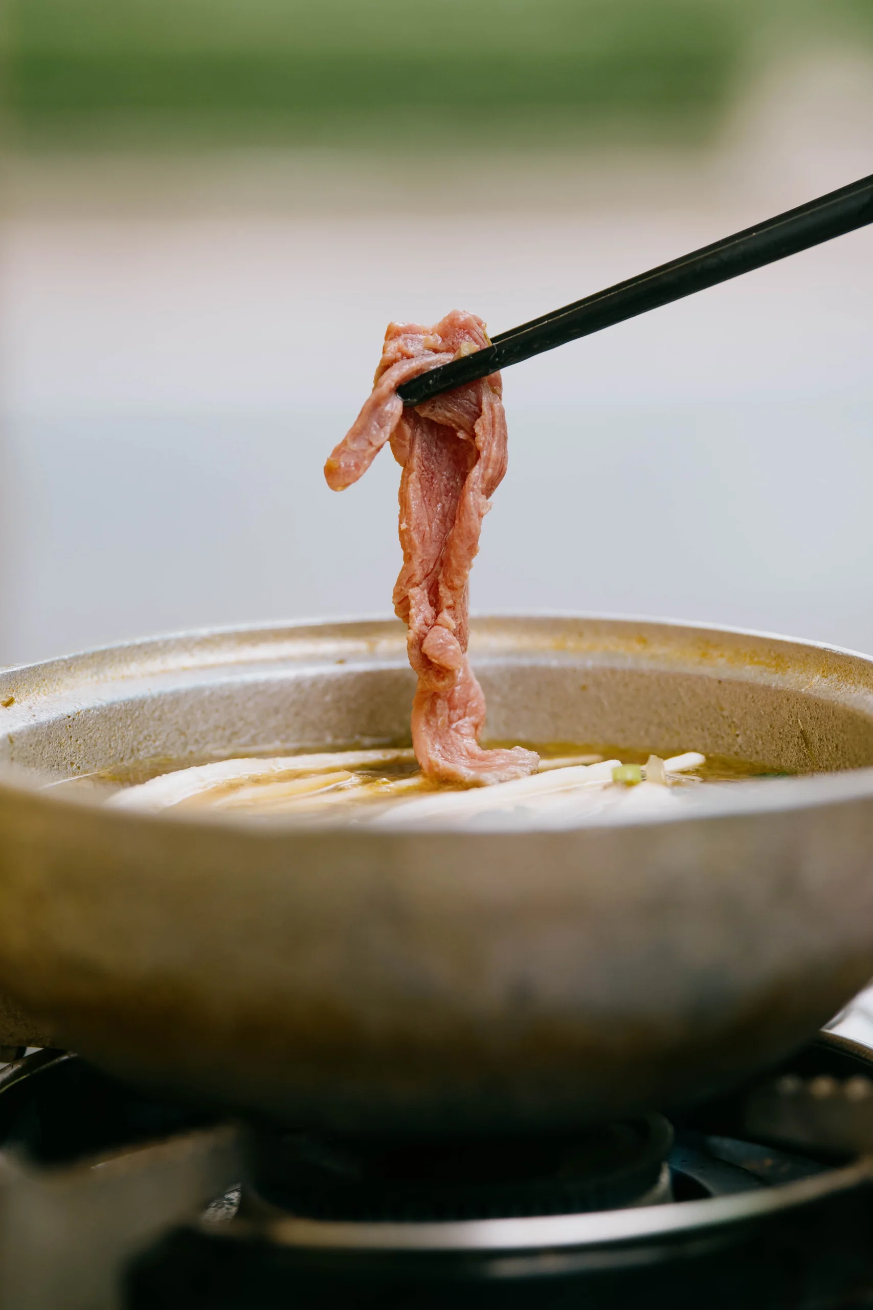 筷子從火鍋中夾起牛肉片
