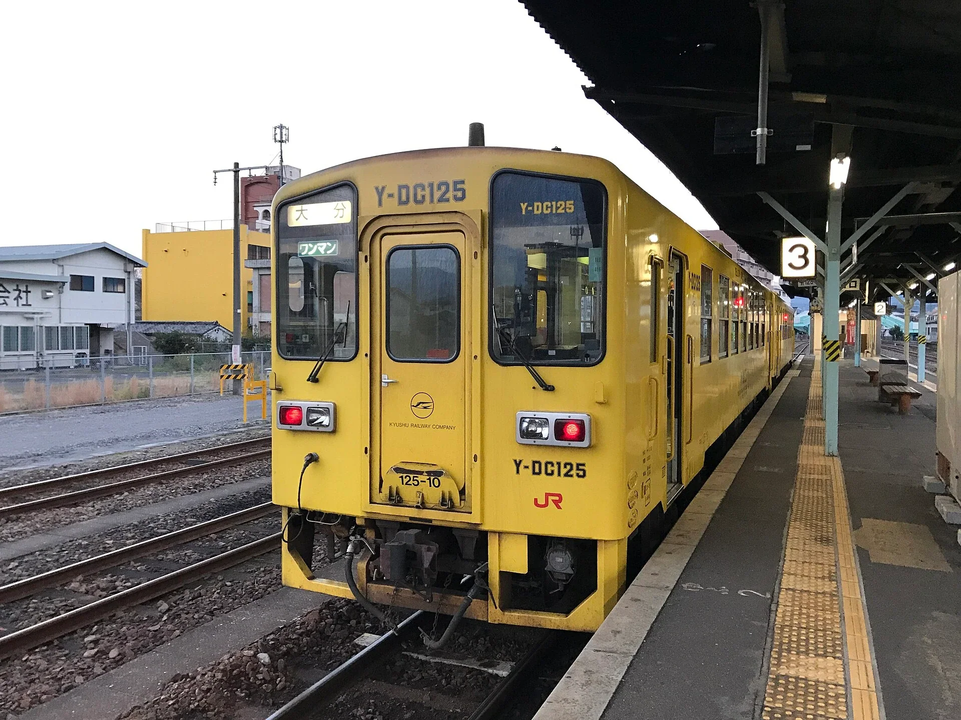日田站月台停靠一列開往大分方向的黃色普通列車