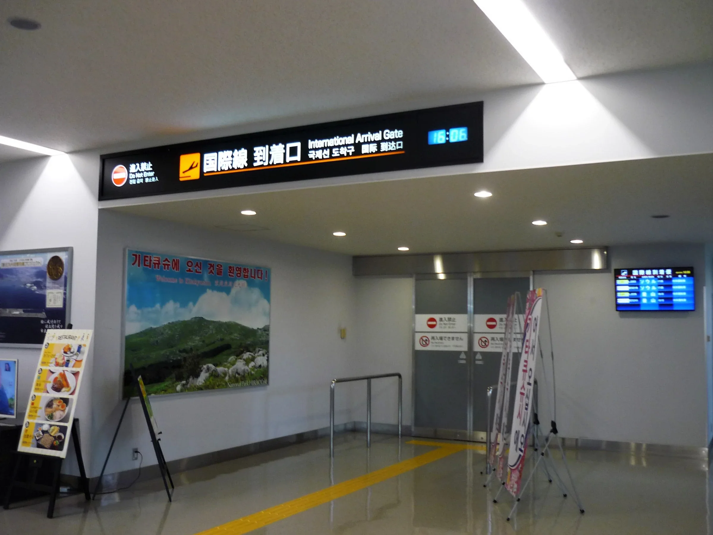 北九州機場國際線抵達口的指示牌、檢查門與抵達資訊螢幕