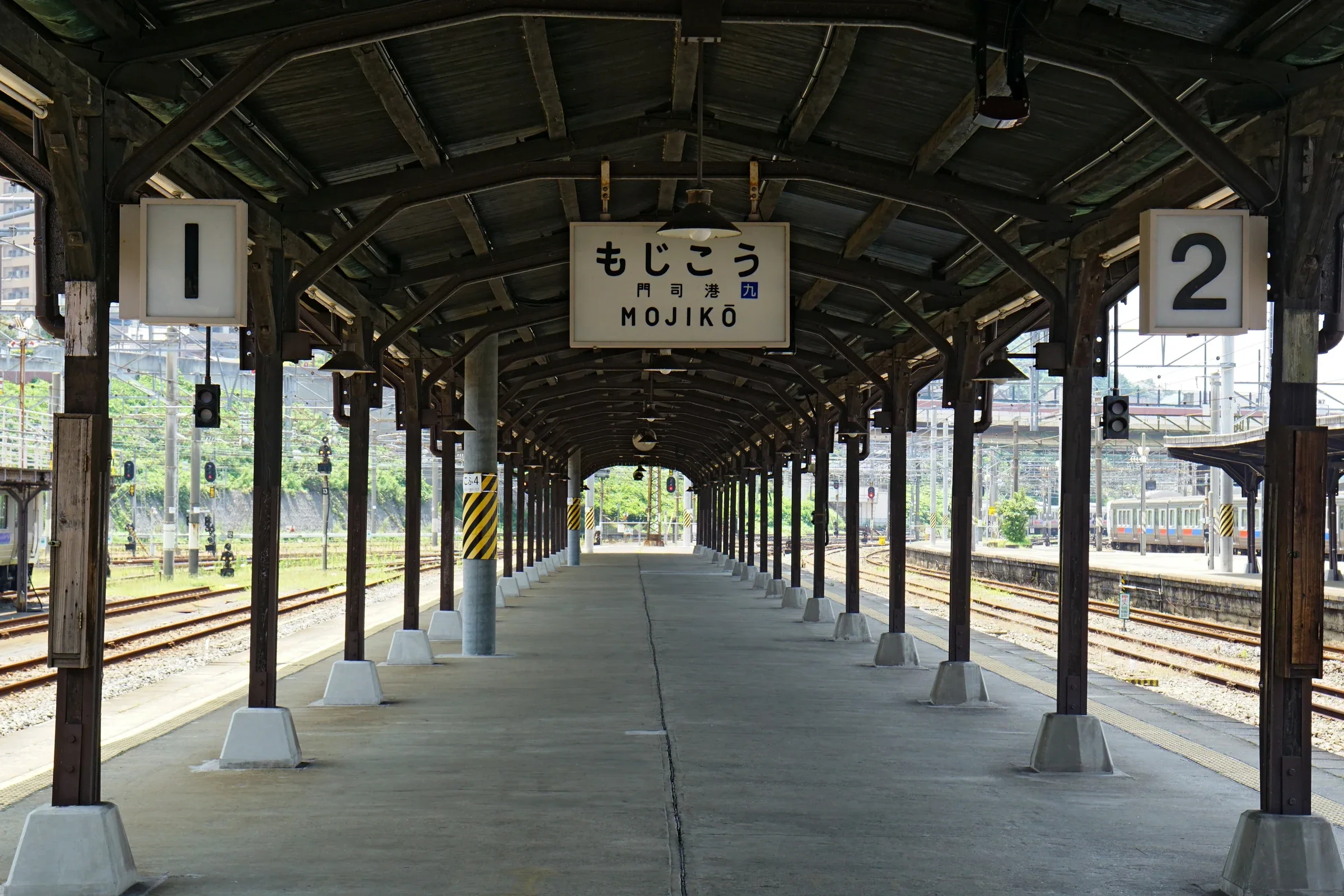 門司港站月台的木構屋頂、站名牌與列車