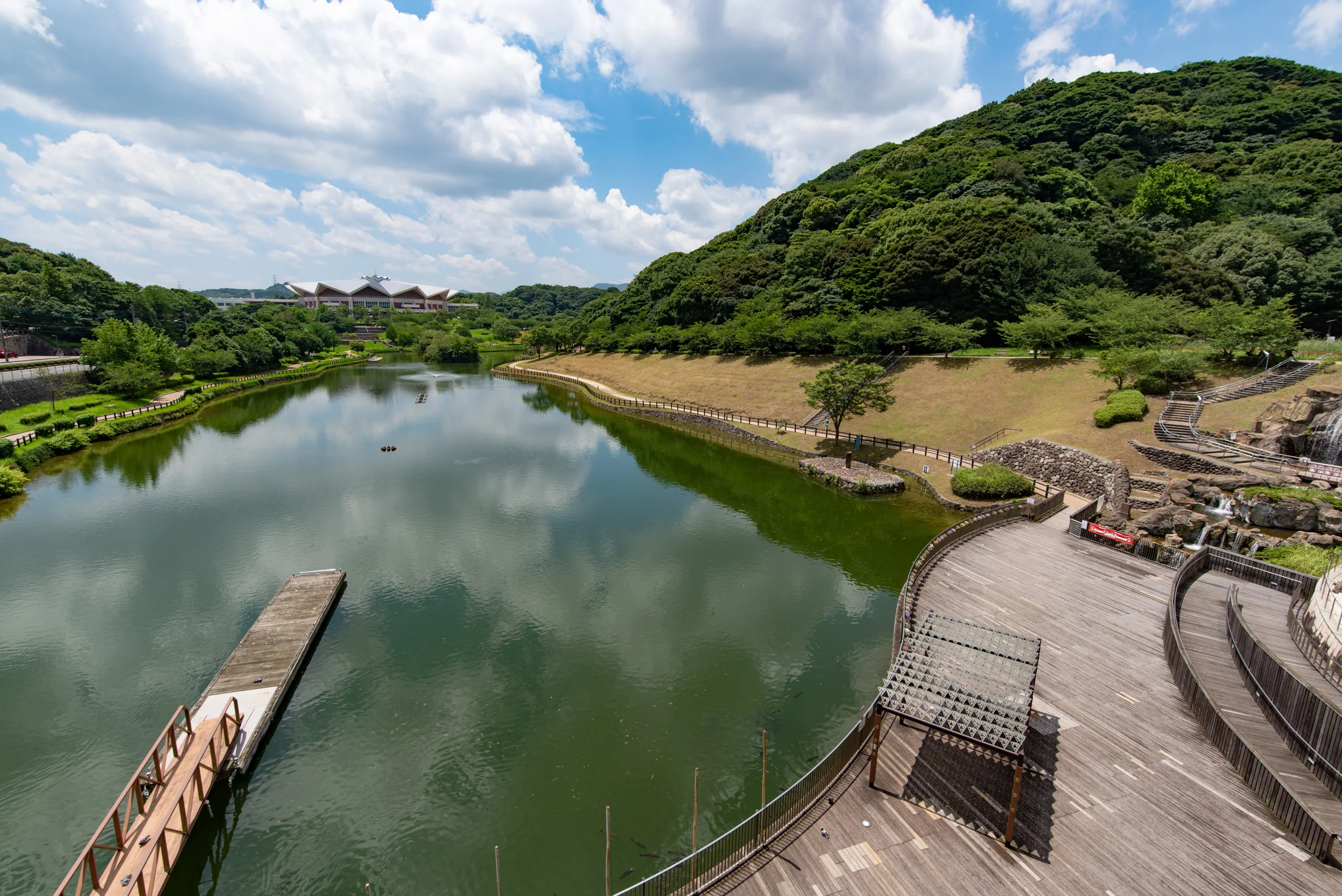 北九州中央公園金比羅池、水邊步道與山坡，畫面沒有粉紅門
