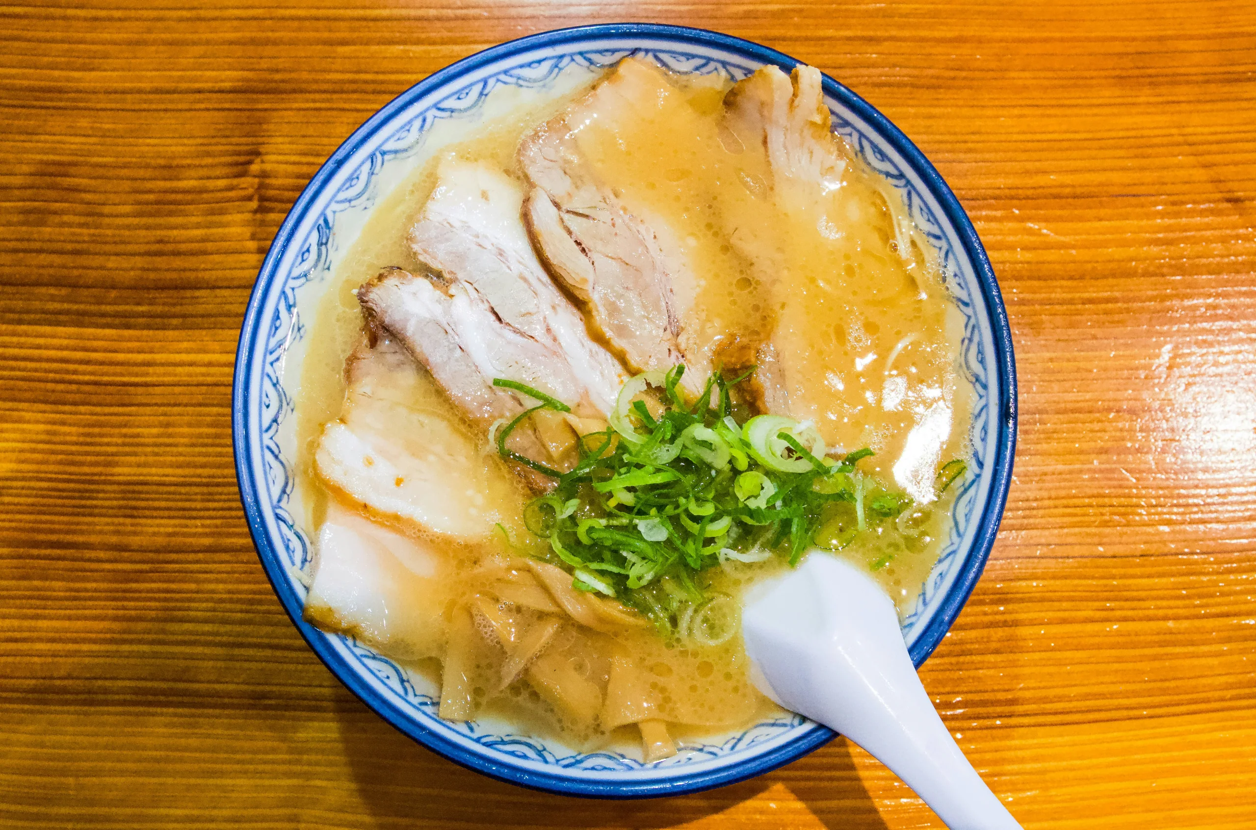 福岡市赤のれん的豚骨拉麵，叉燒與青蔥放在白色湯頭上