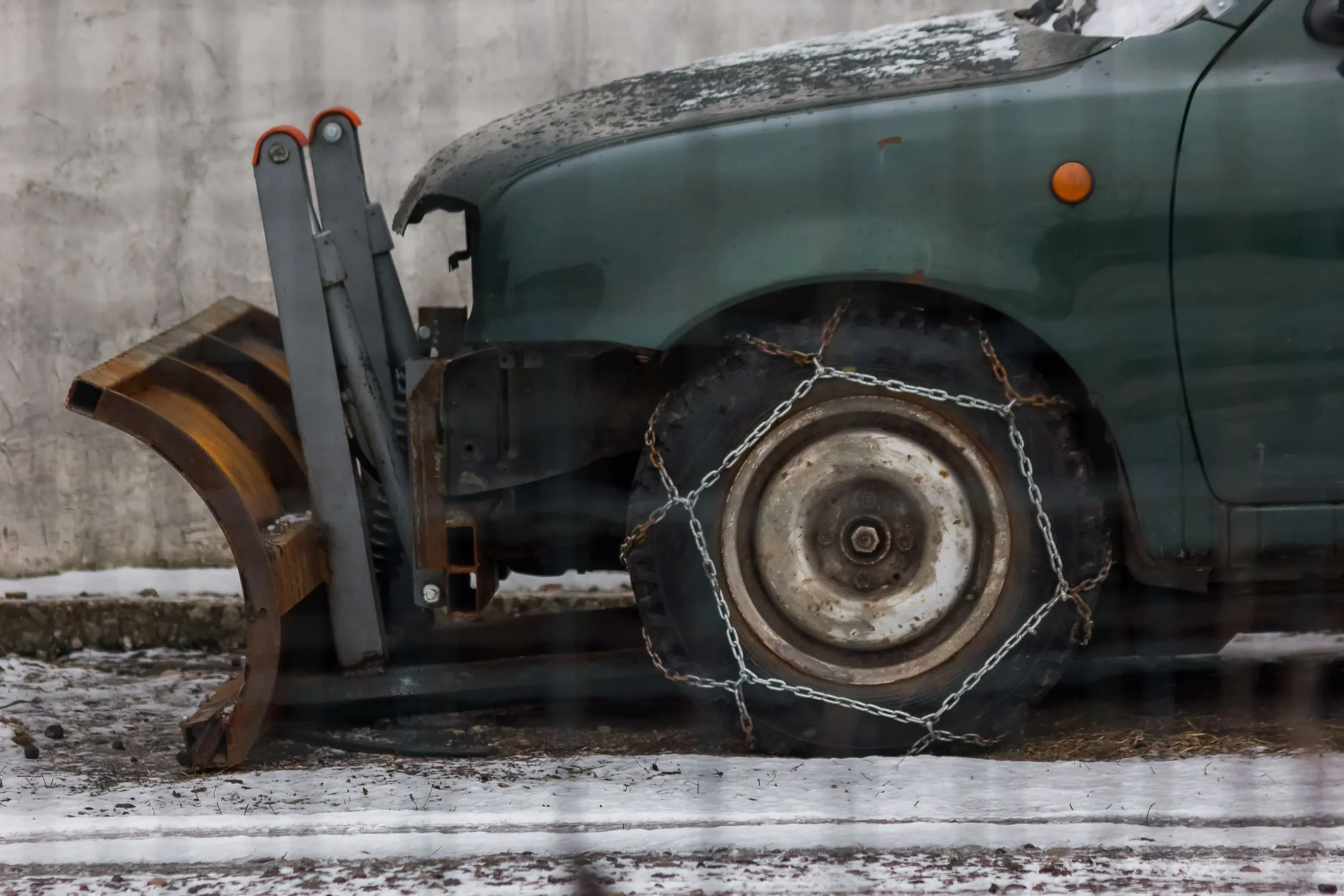除雪車車輪套有金屬雪鏈，車輪停在薄雪地面