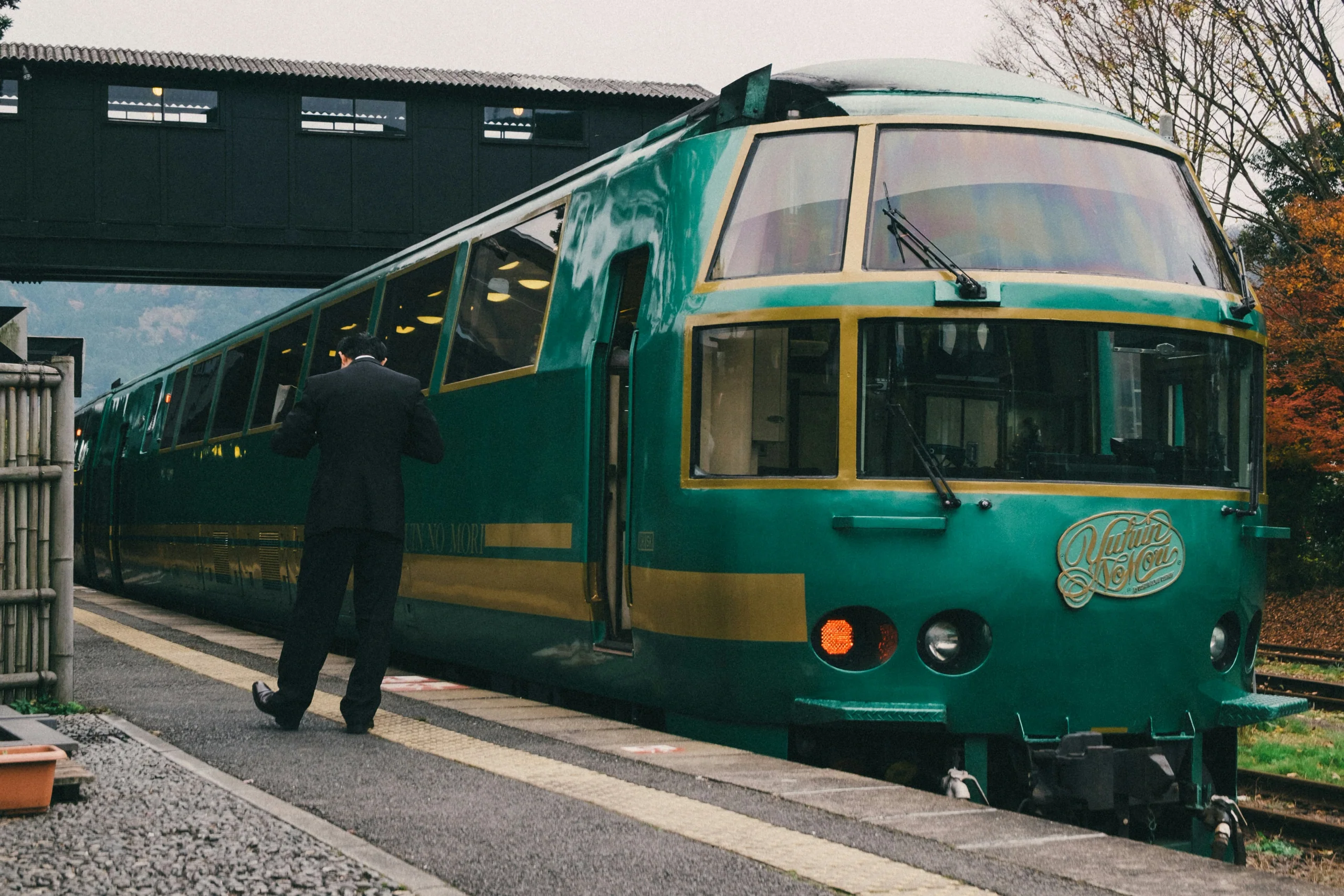 綠色與金色的由布院之森觀光列車停靠由布院站